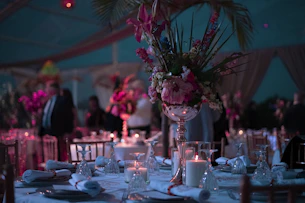 a table with a vase of flowers and candles on it