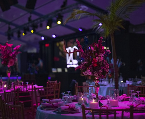 a table set up for a party with candles and flowers