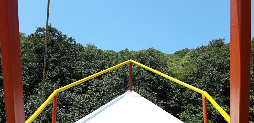 a white and yellow structure with trees in the background