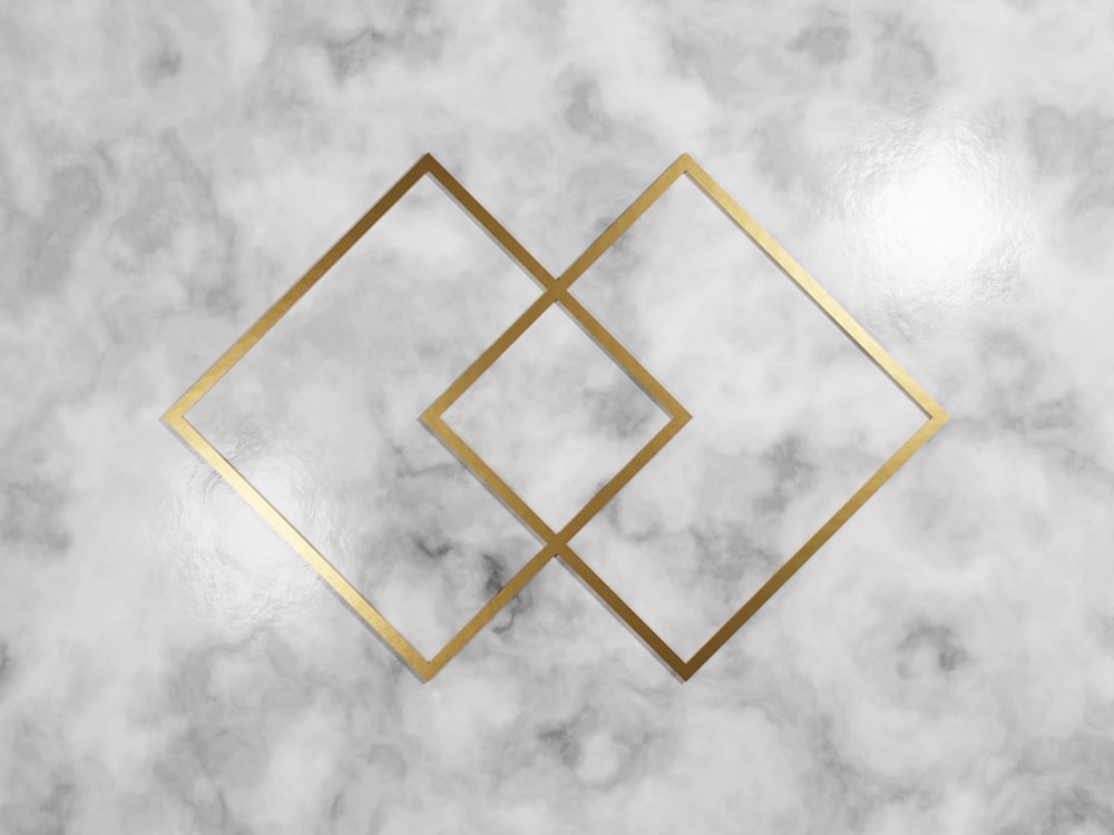 a white marble wall with a gold geometric design