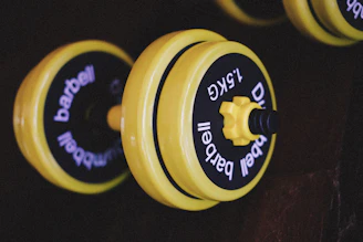 a row of yellow and black dumbbells on a wall