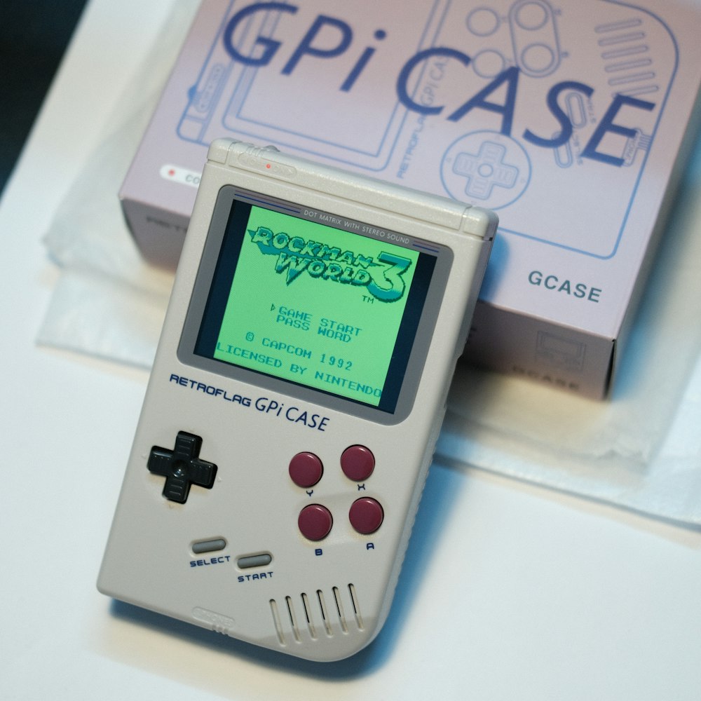 a gameboy sitting on top of a table next to a box