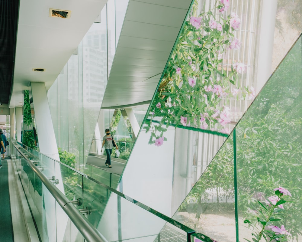 a woman walking down a walkway next to a tall building