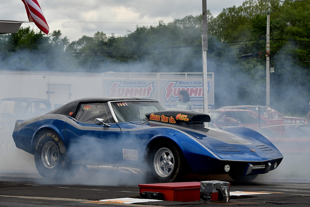 a blue race car with smoke coming out of it