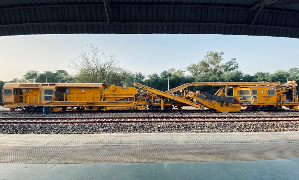 a yellow train car sitting on top of train tracks