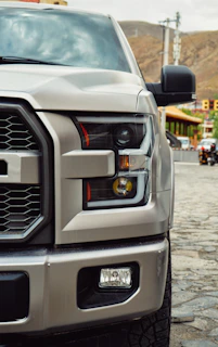 a silver truck parked on a cobblestone street