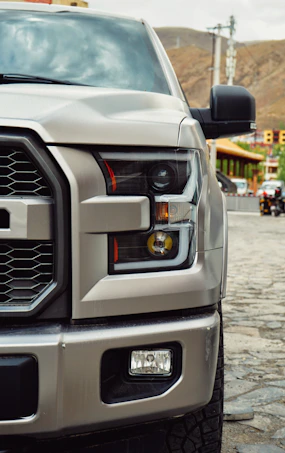 a silver truck parked on a cobblestone street