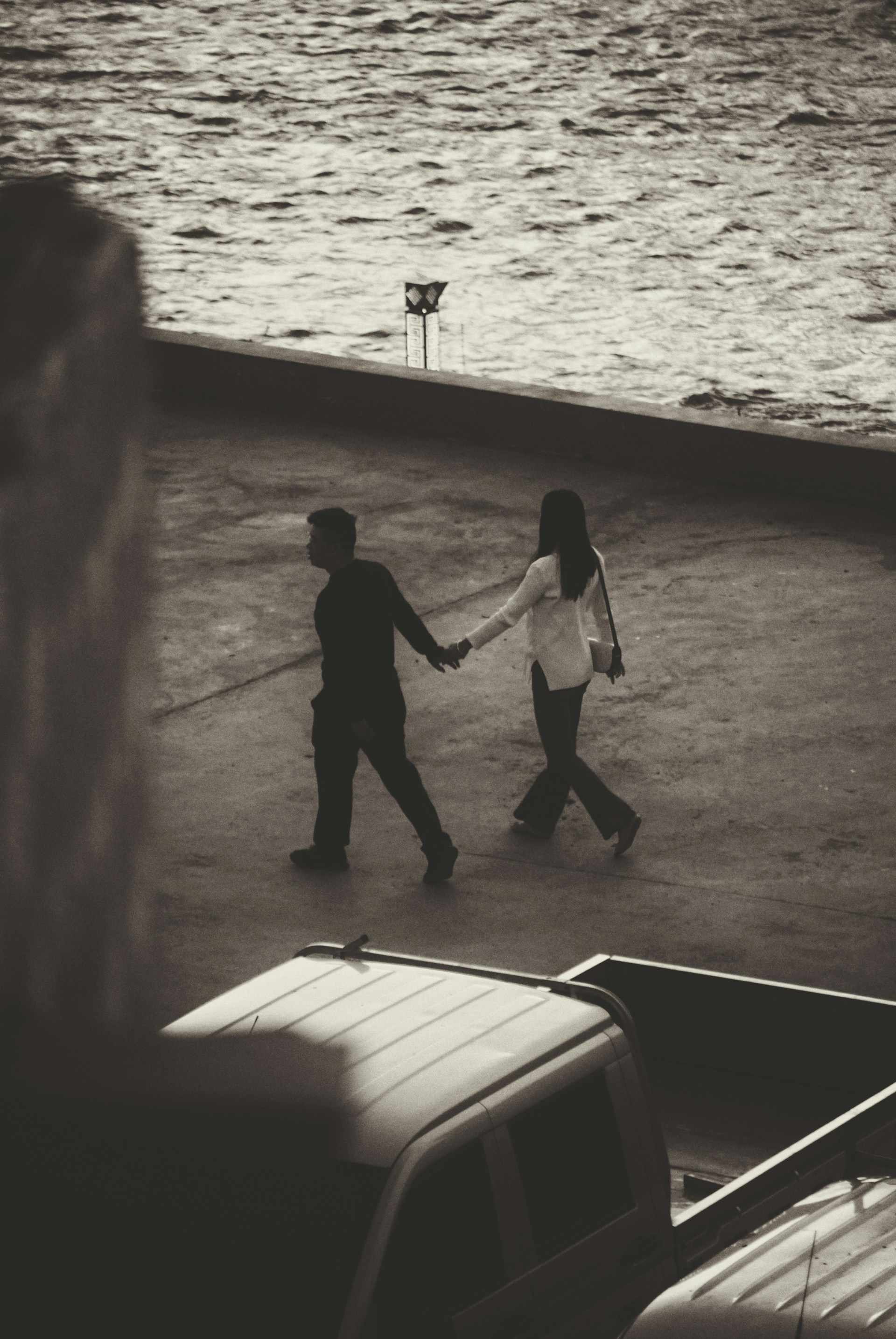 a couple of people walking across a parking lot