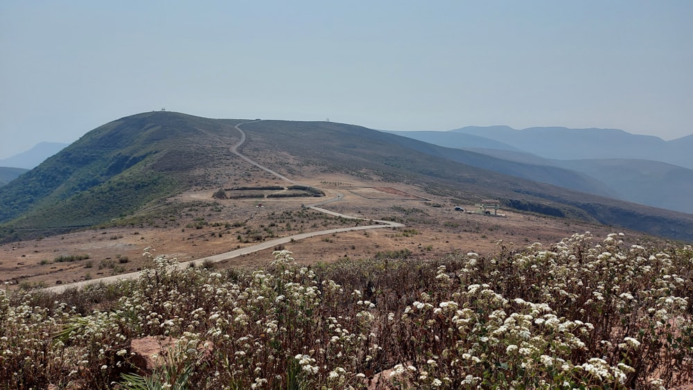 a dirt road going up a hill in the mountains