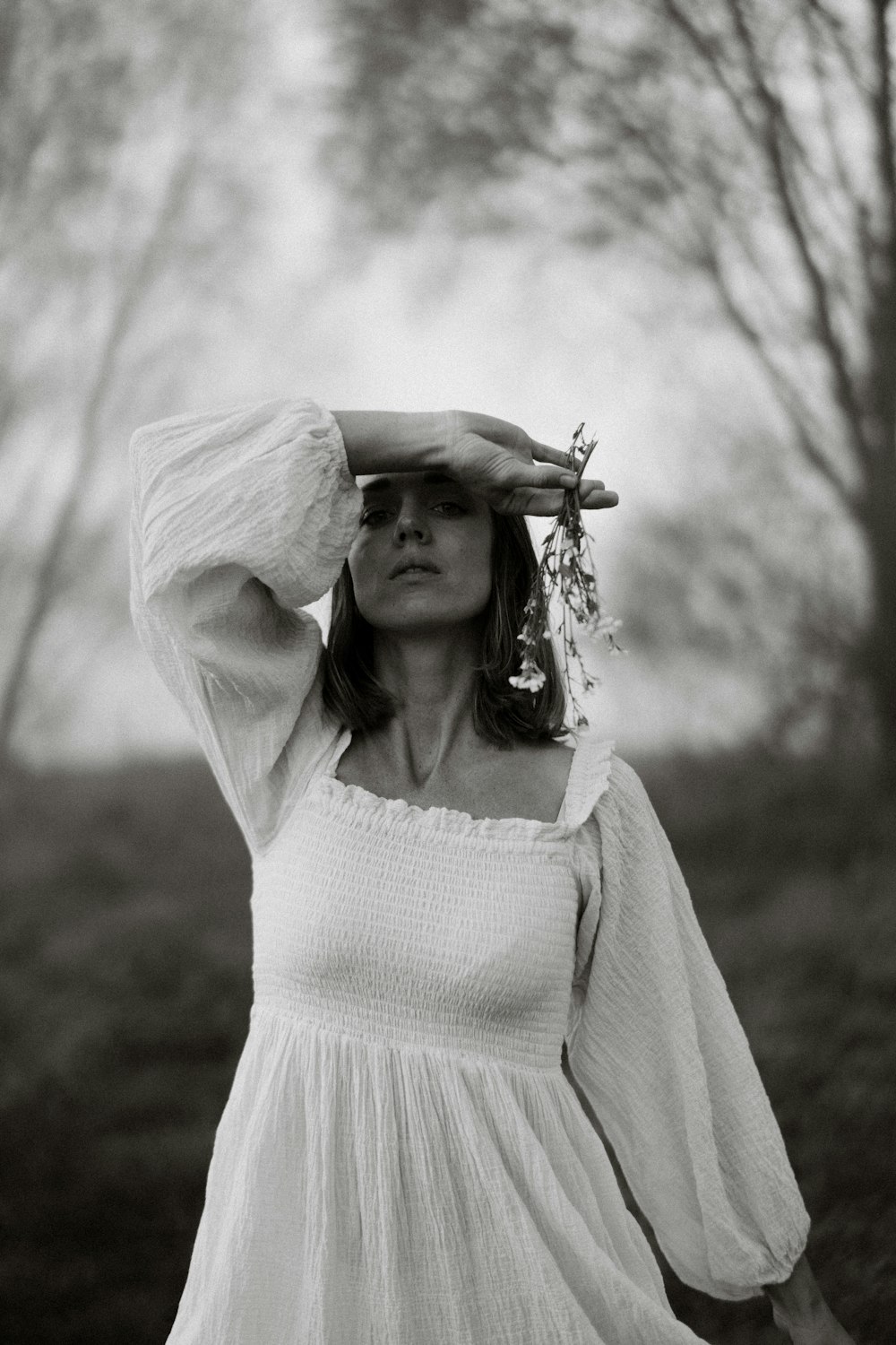 a woman in a white dress is holding her hands on her head