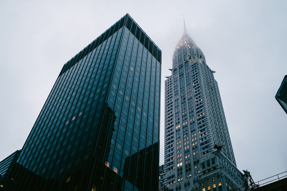 two skyscrapers in a city with a foggy sky