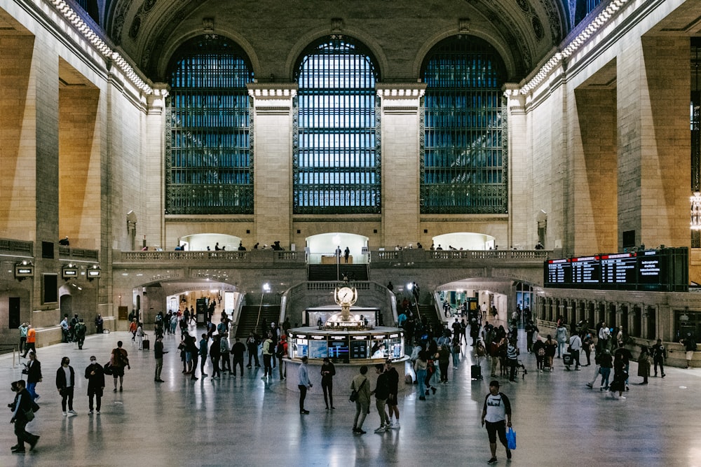 a group of people walking around a train station