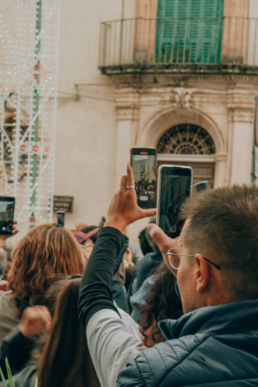 a group of people taking pictures with their cell phones