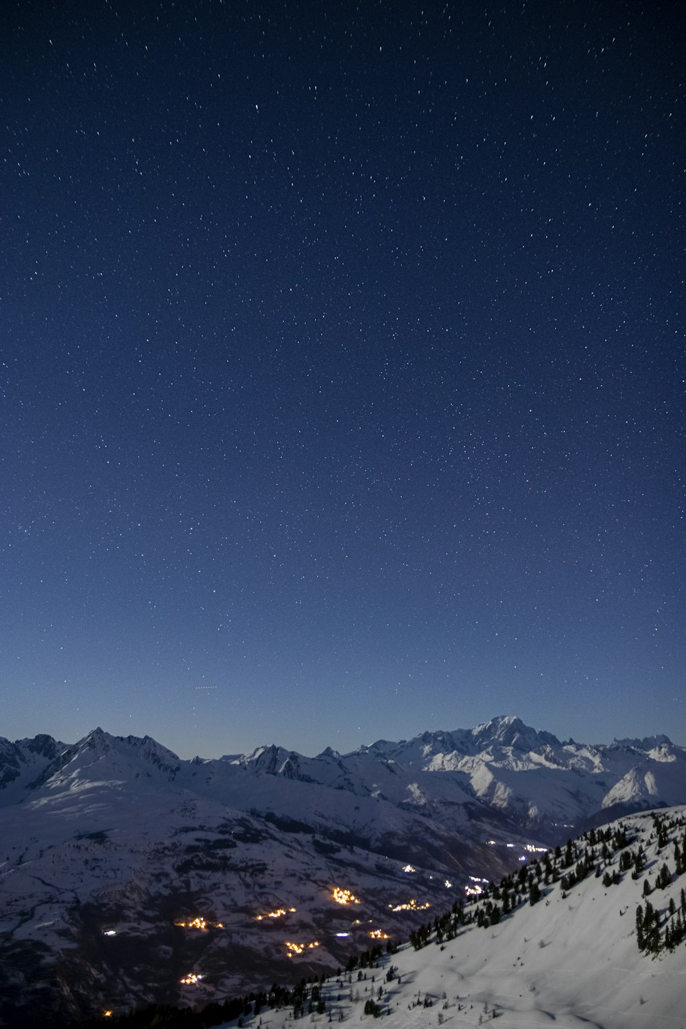 a view of a mountain at night with stars in the sky