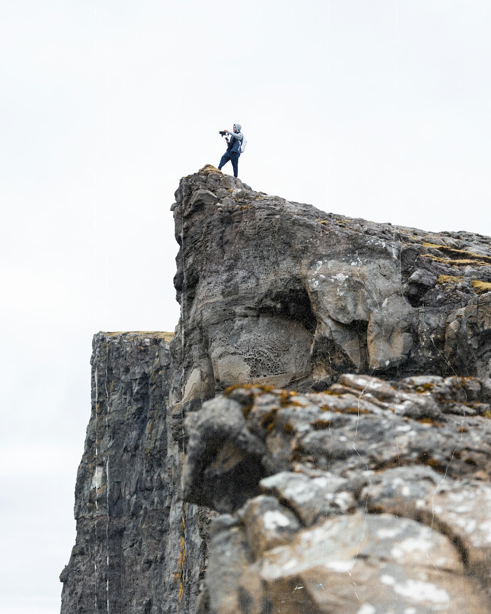 a man standing on top of a rock cliff