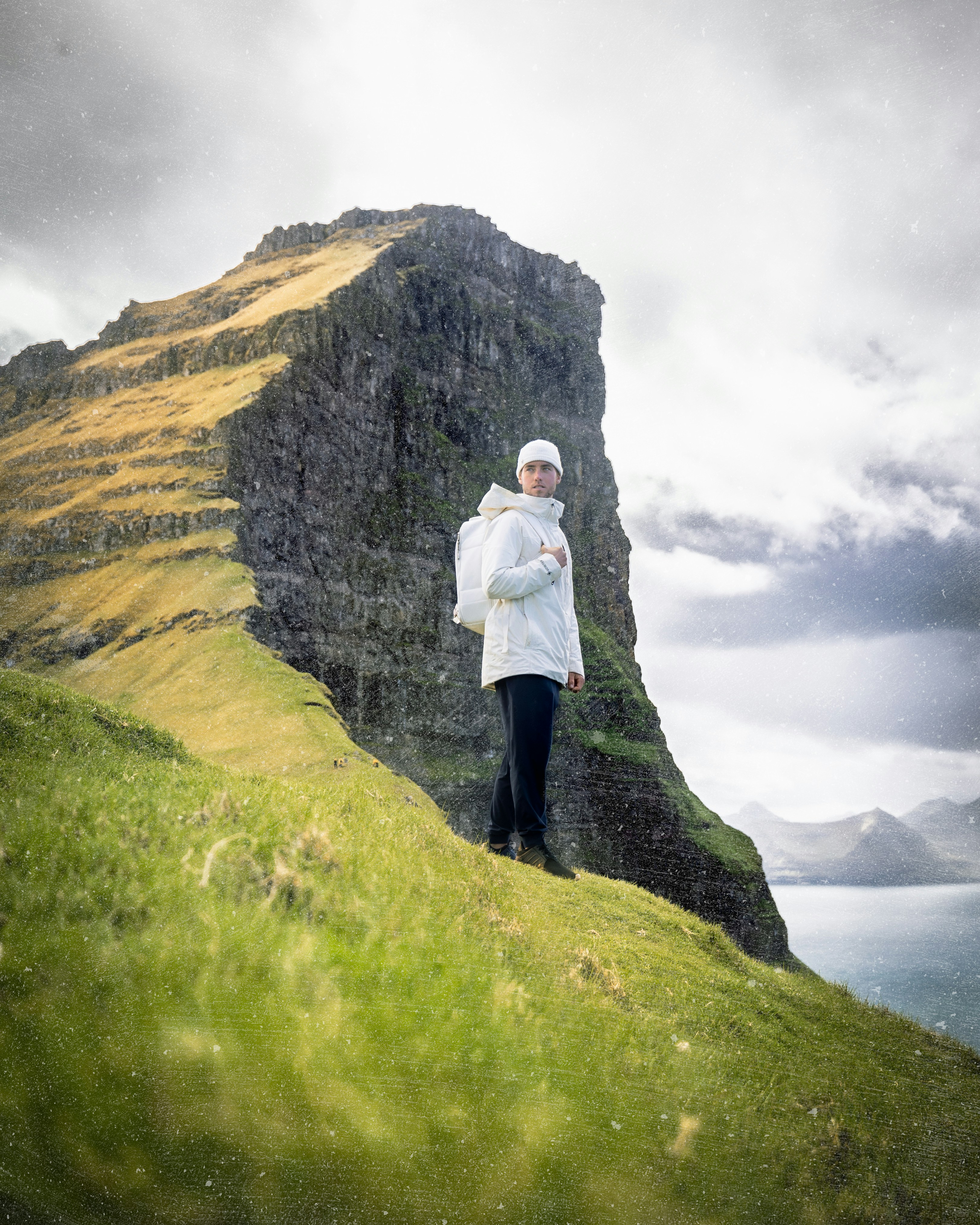 a man standing on top of a lush green hillside