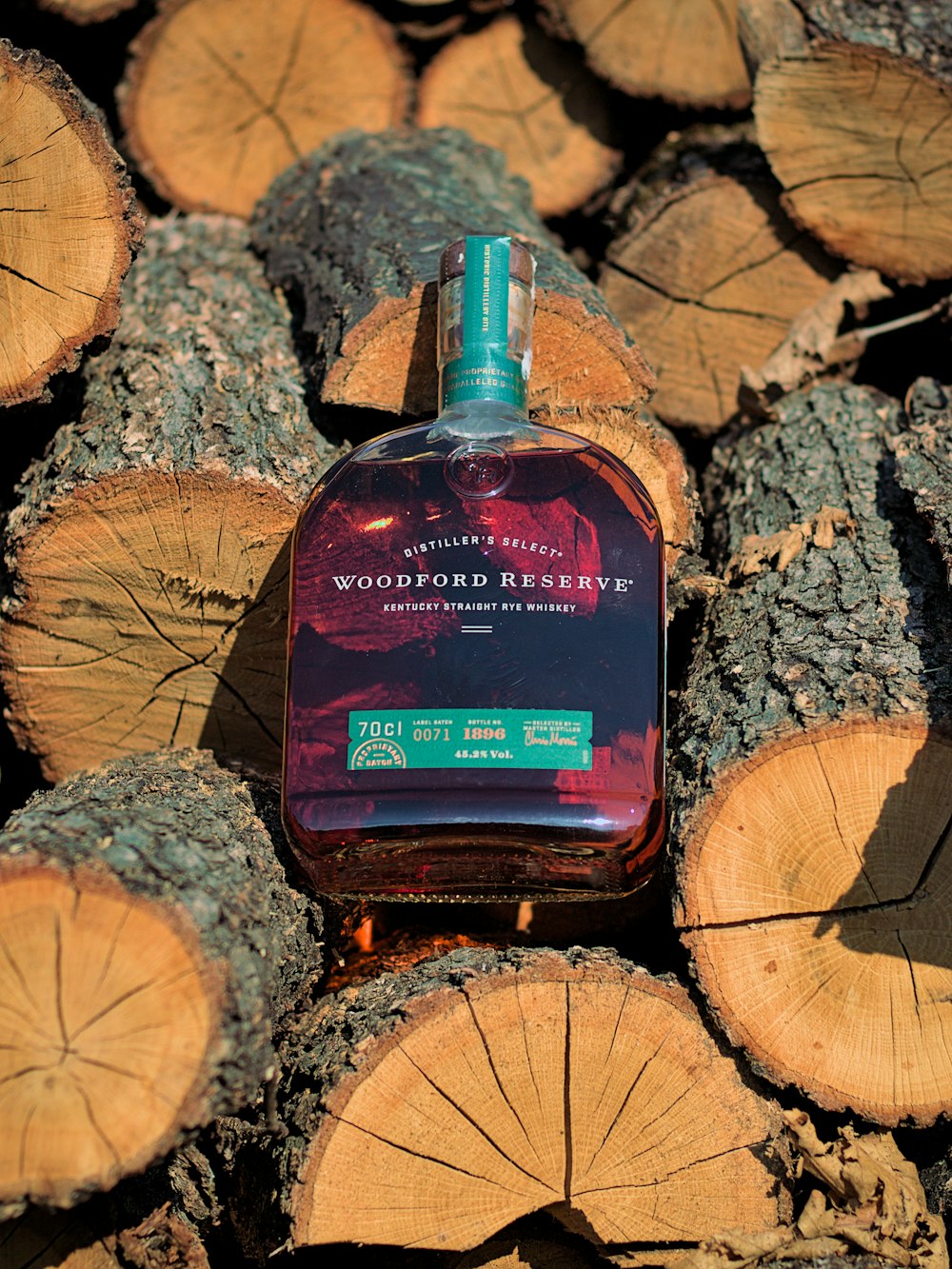 a bottle of wood spirit sitting on top of a pile of logs