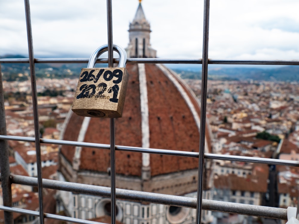 a padlock on a fence with a view of a city