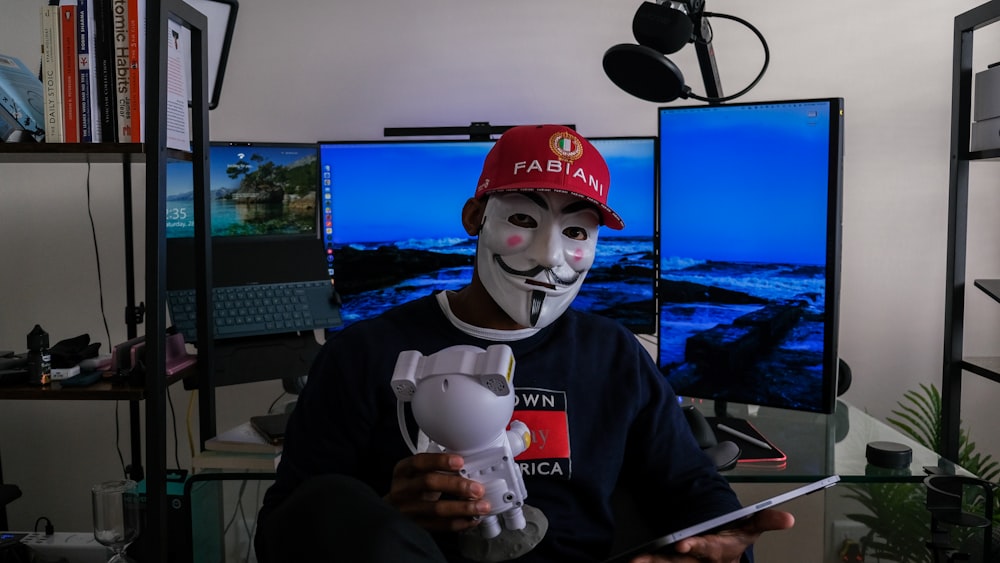 una persona che indossa una maschera e tiene in mano un controller per videogiochi