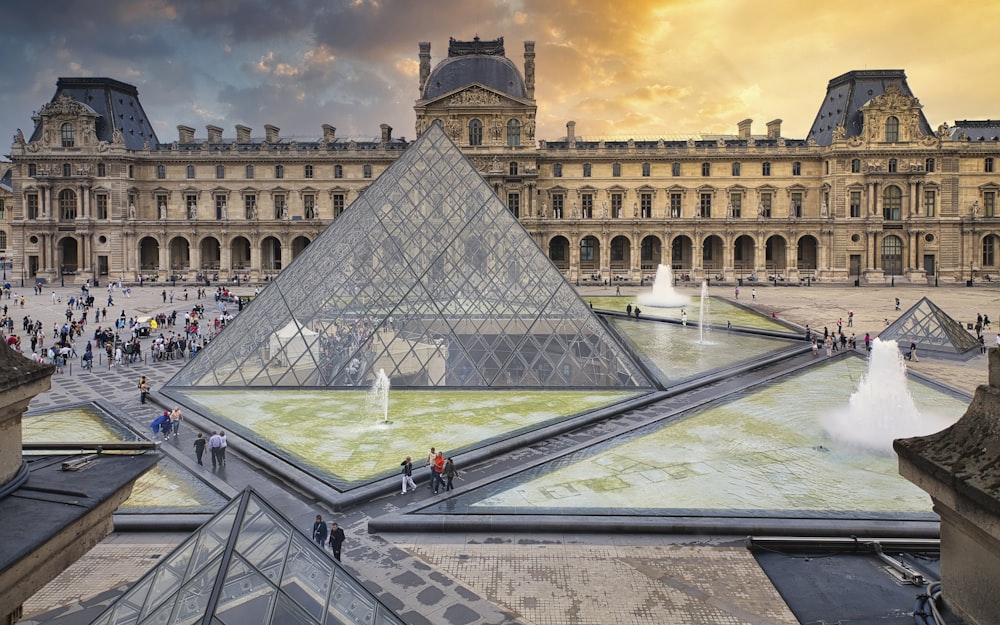 Un edificio a forma di piramide con una fontana di fronte ad esso