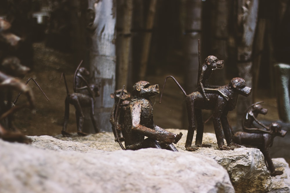 a group of metal figurines sitting on top of a rock