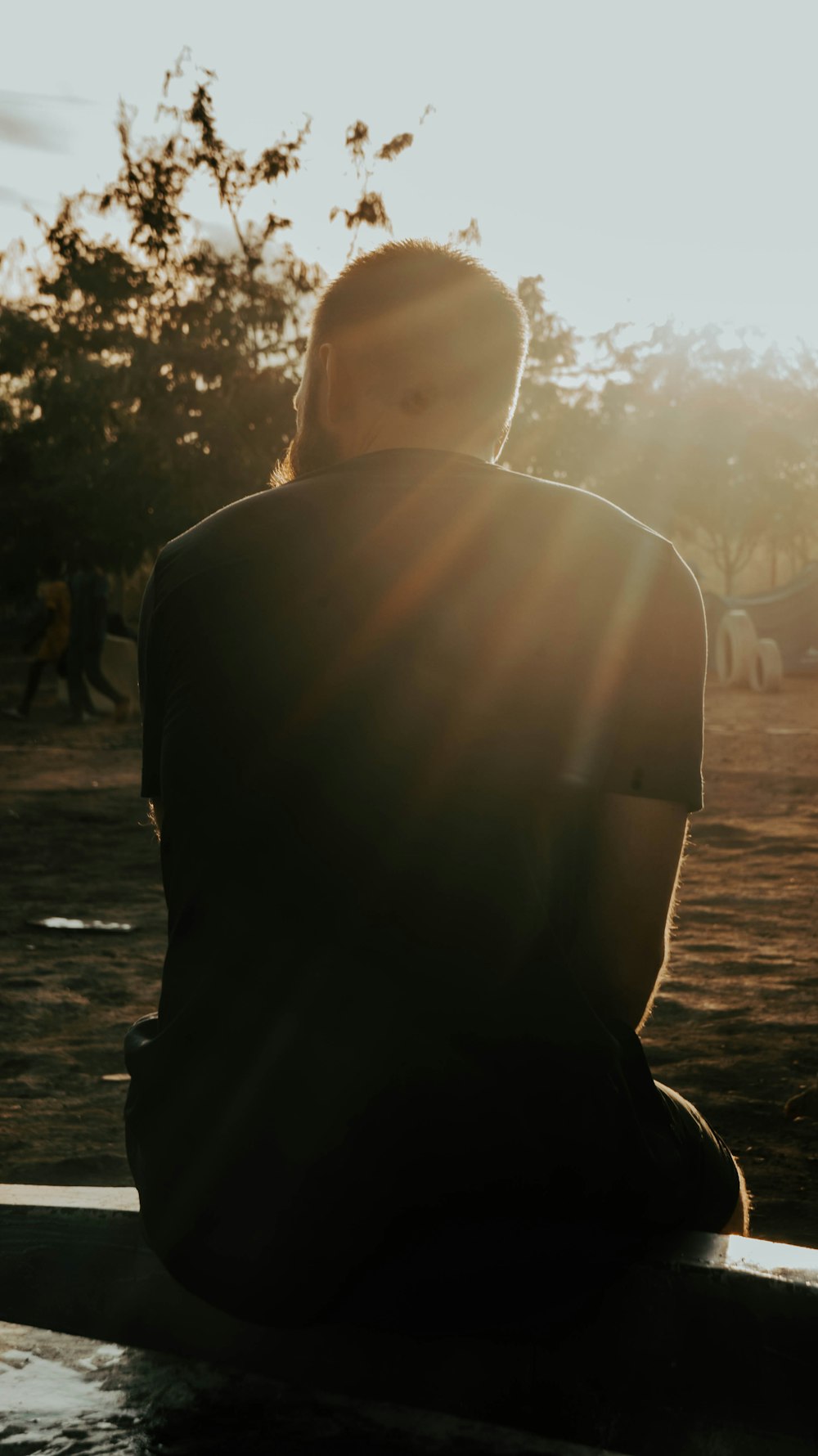 a person sitting on a bench in the sun