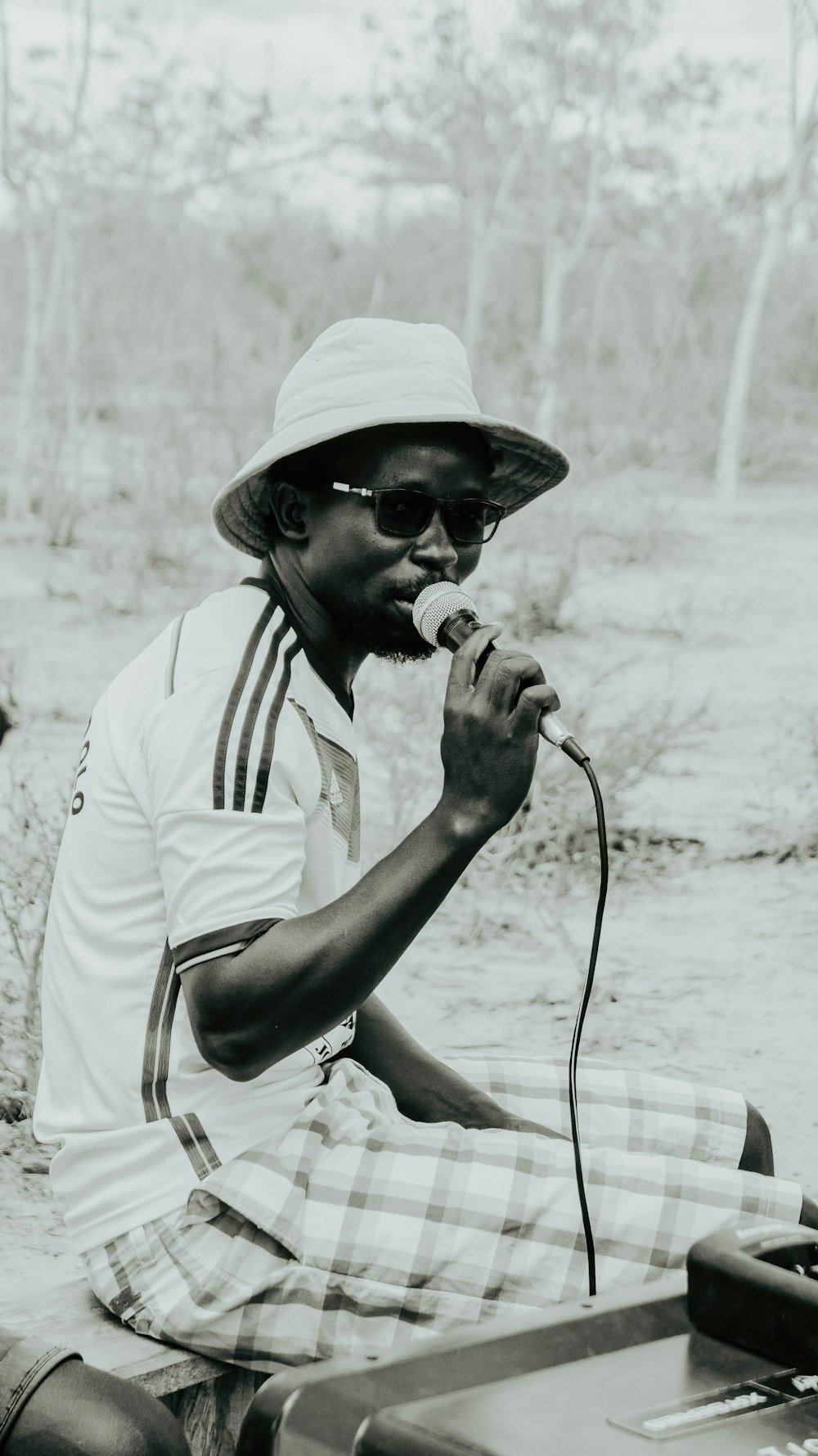 a man sitting on the ground with a microphone in his hand