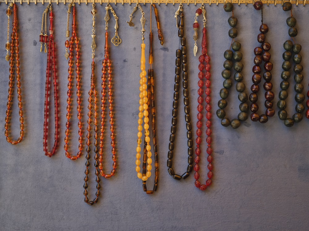 eine Reihe von Halsketten, die an einer Wand hängen