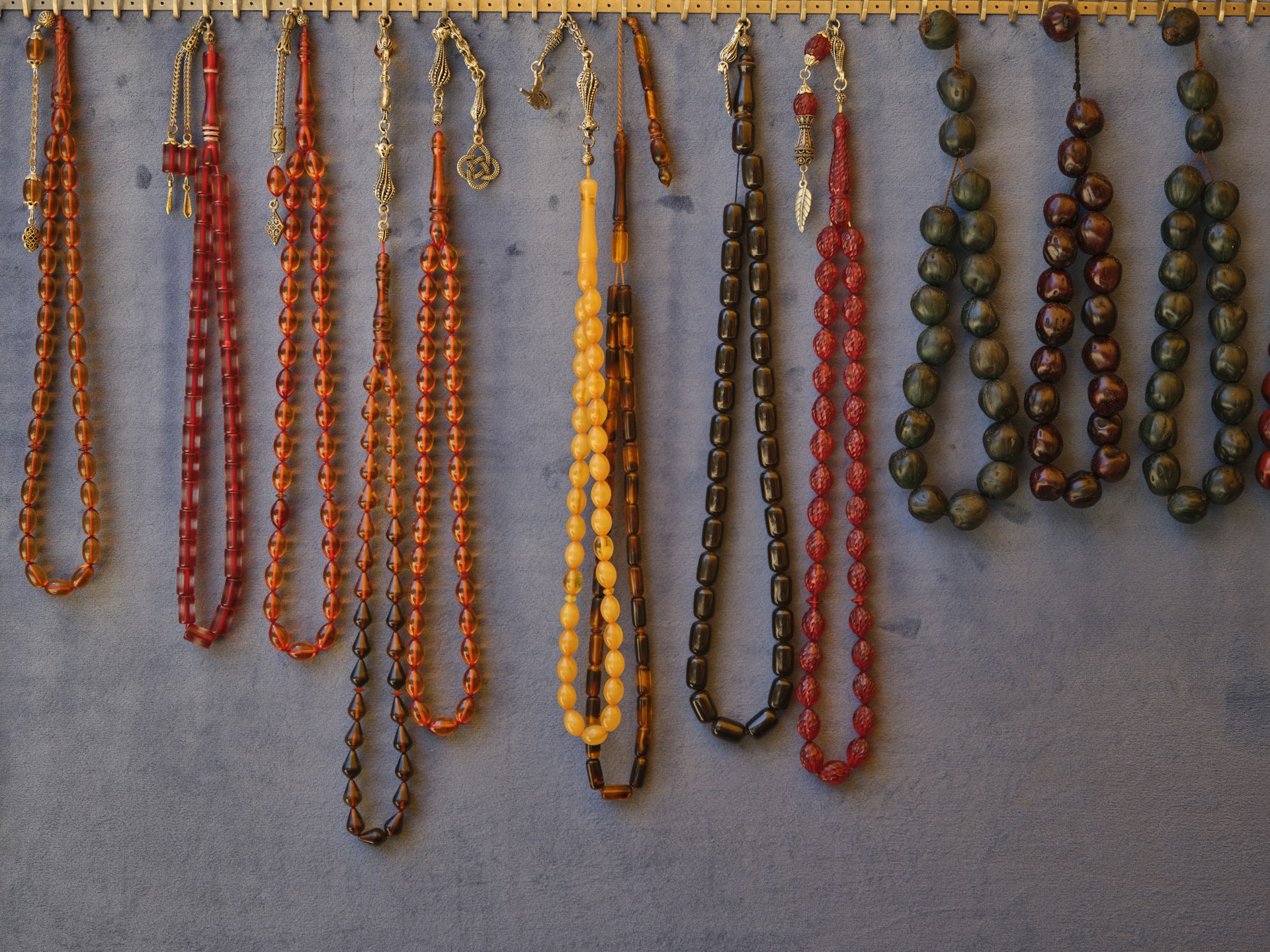 a number of necklaces hanging on a wall