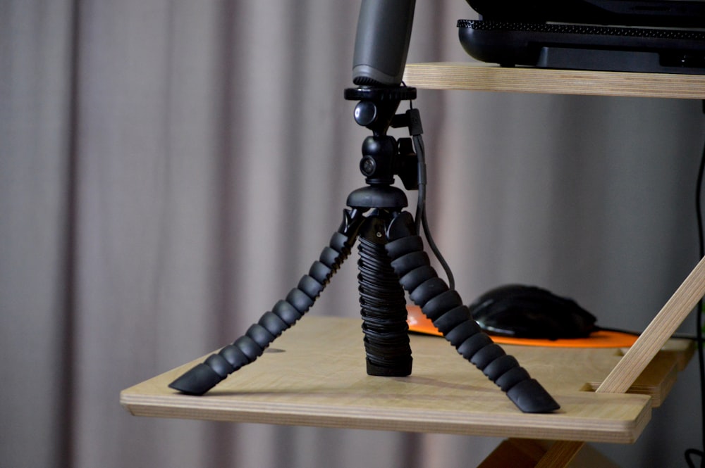 a tripod sitting on top of a wooden shelf