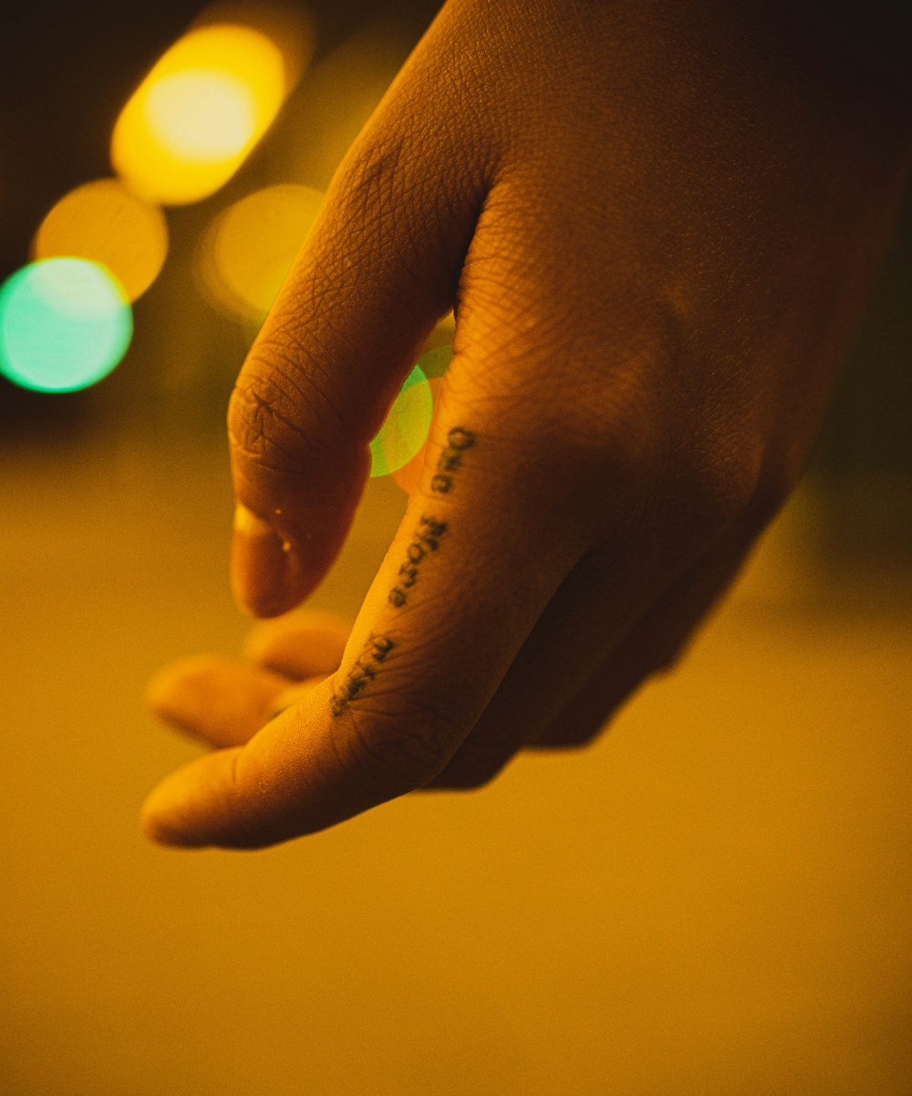a person's hand with a small tattoo on it