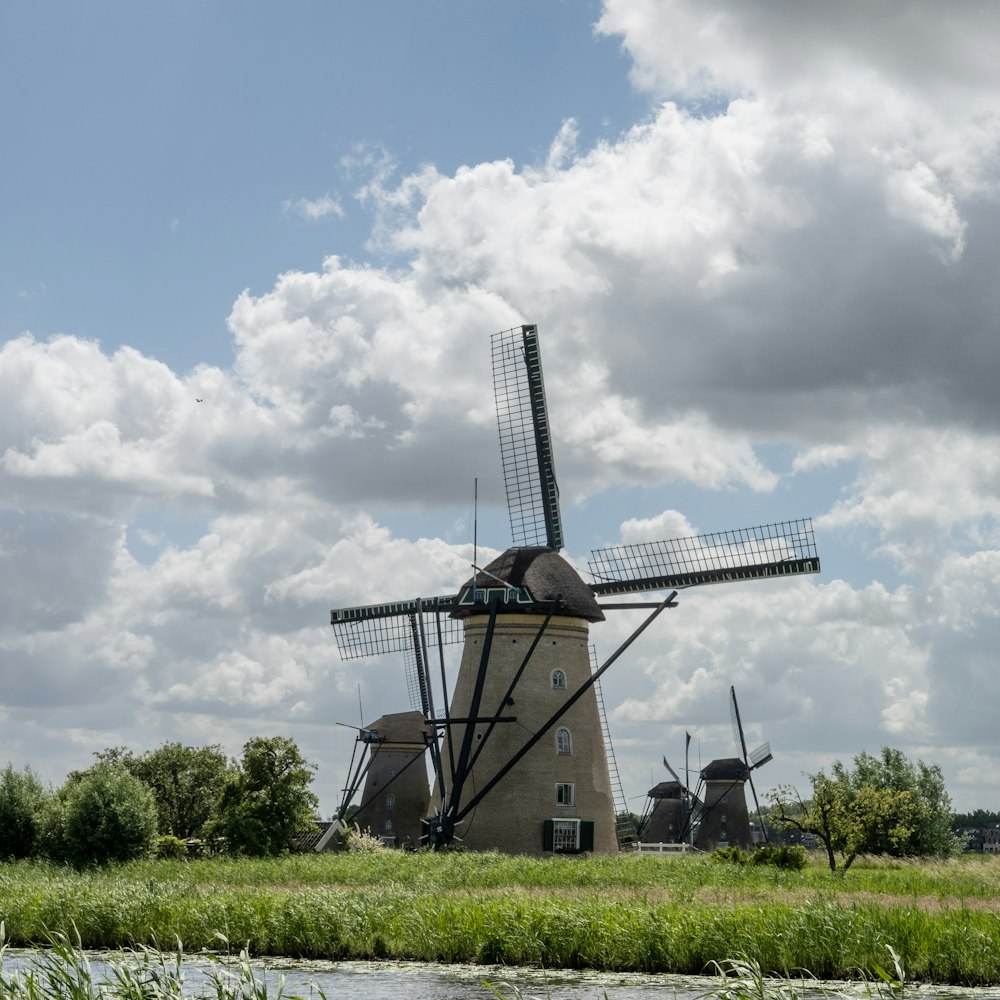 a windmill in the middle of a grassy field