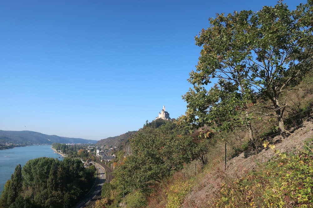 a scenic view of a river and a church on a hill