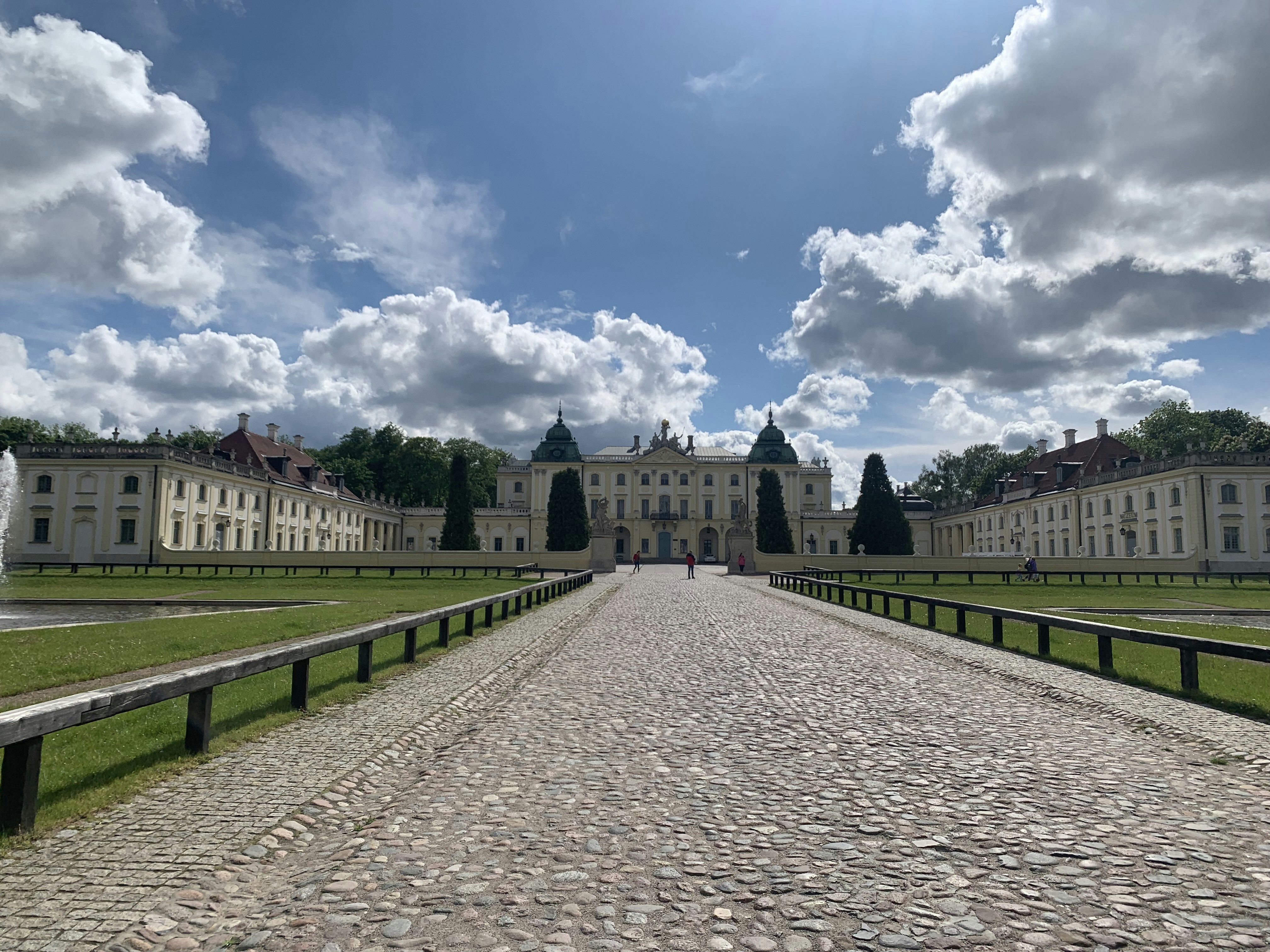 une route de pierre devant un grand bâtiment