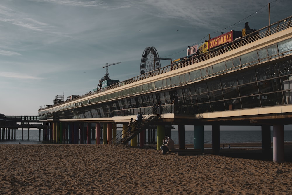 a boardwalk next to the ocean with a roller coaster in the background