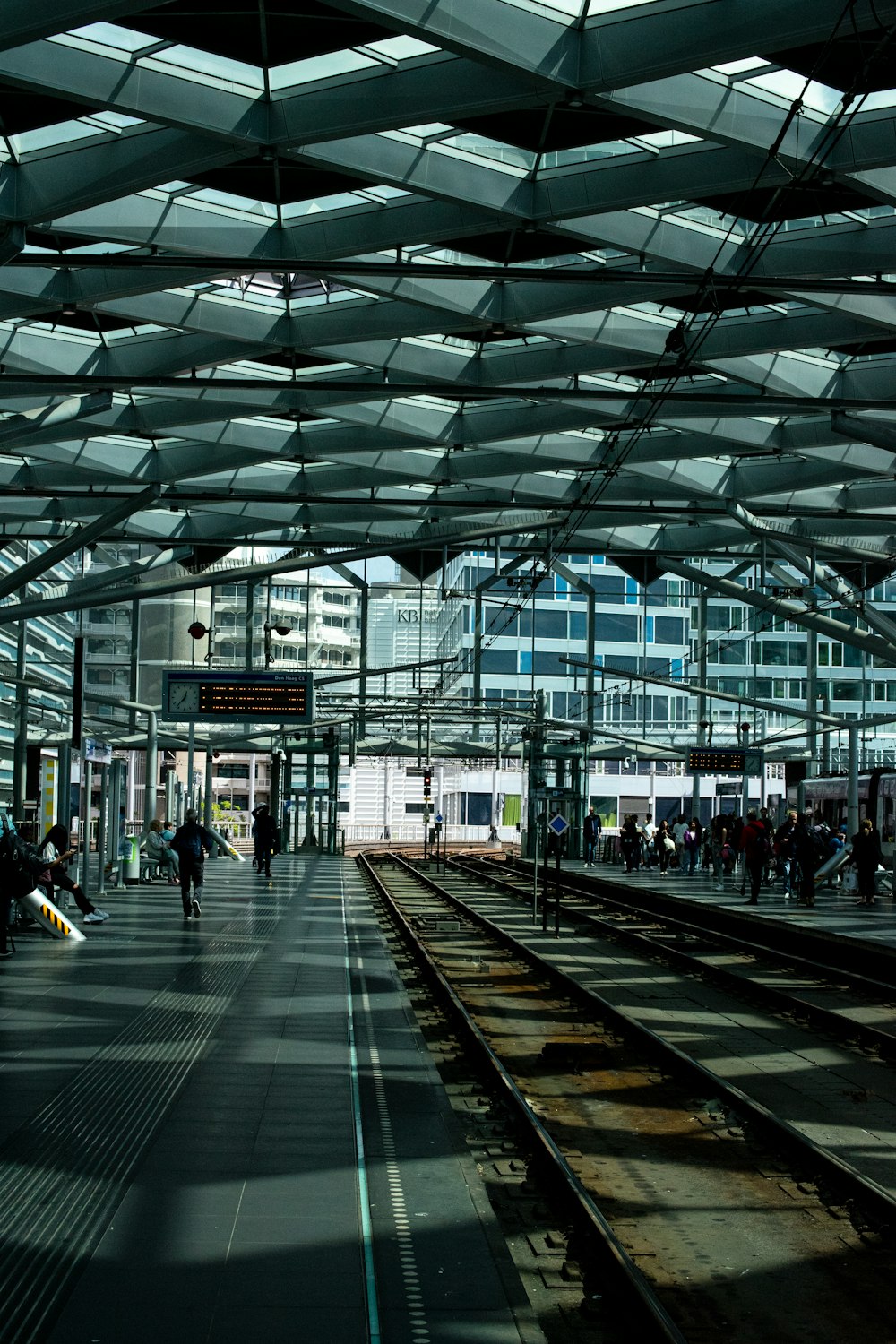 a train station with people waiting for their trains