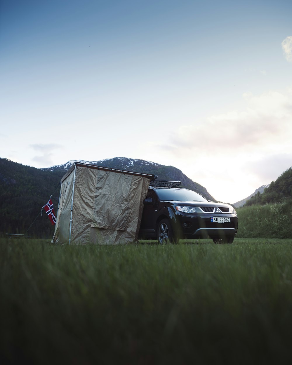 a car parked in a field with a tent on top of it