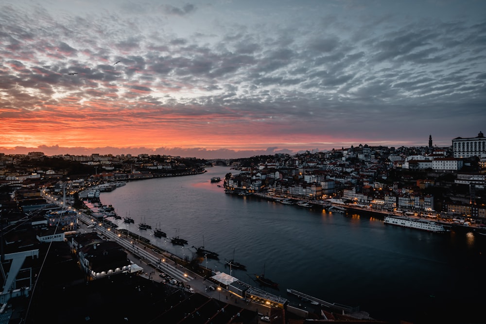 a sunset over a river with a city in the background