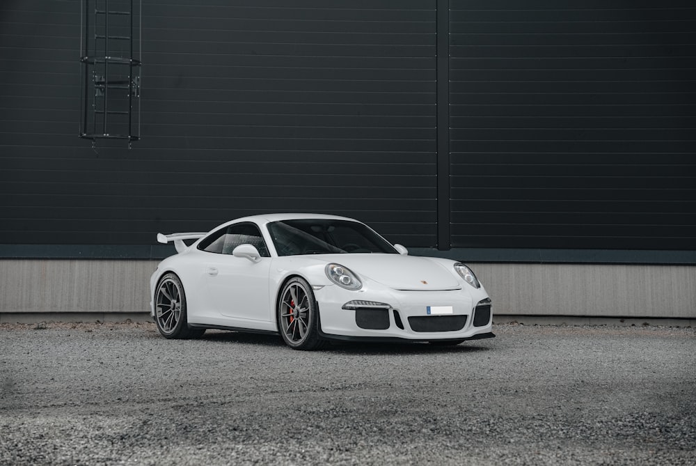 a white sports car parked in front of a building