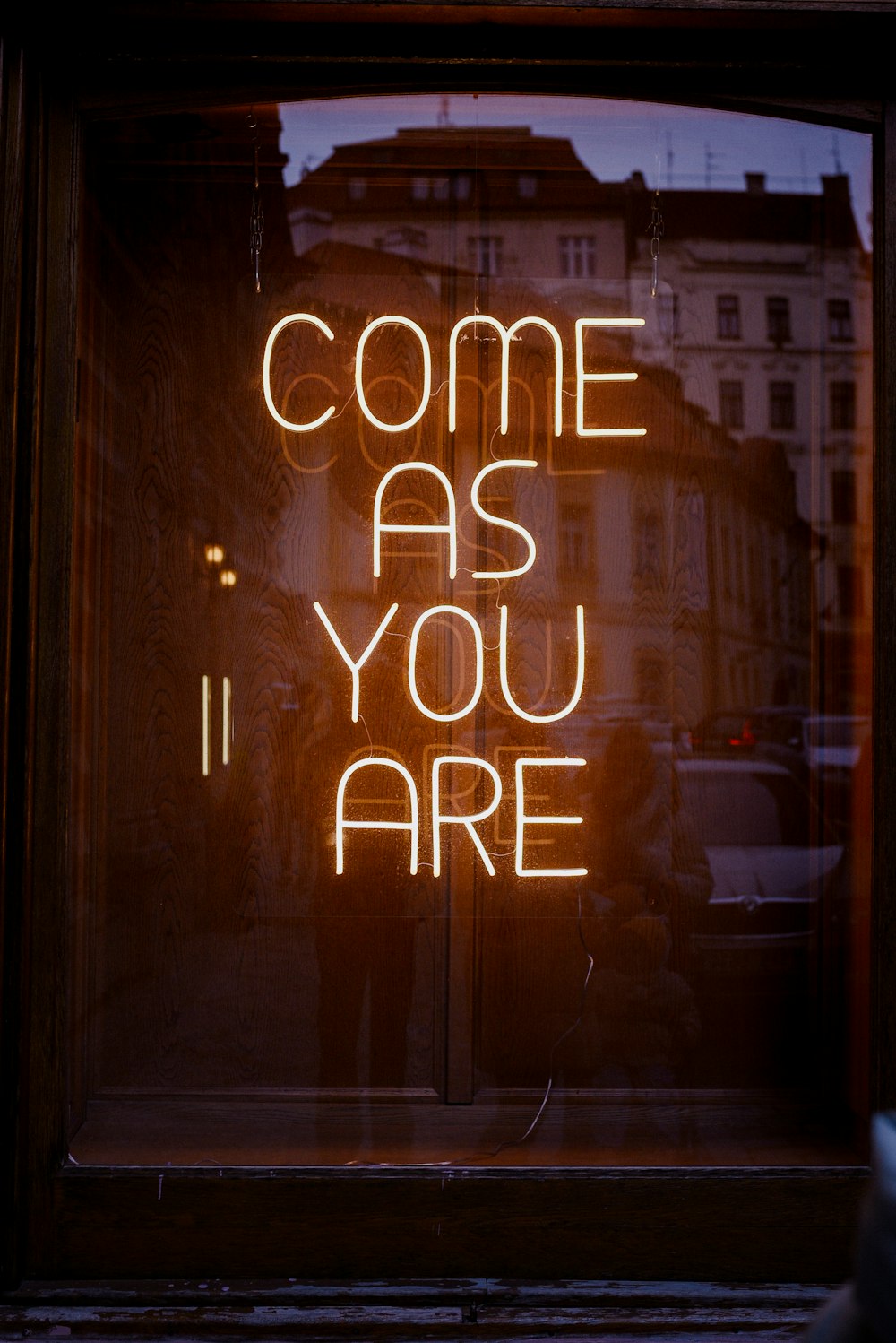 a neon sign that reads come as you are