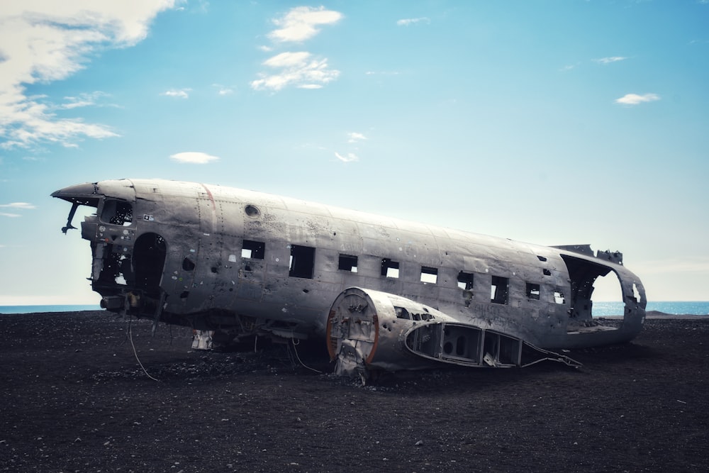 an old airplane sitting on top of a dirt field
