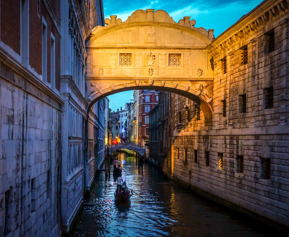 a small boat is going under a bridge