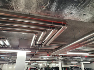 A modern multi-level parking garage with visible fire safety systems and ventilation ducts.