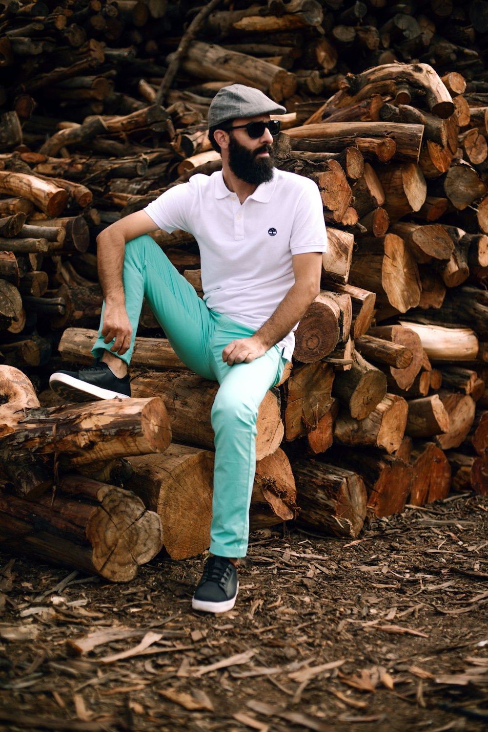 a man sitting on top of a pile of logs