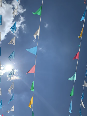 Children smiling and waving Liberian flags during a family-friendly parade under sunny skies.