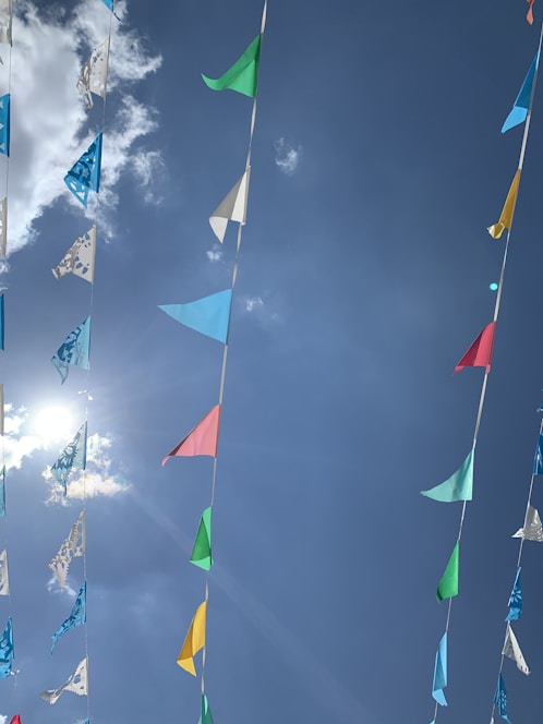 A bright, cheerful school playground filled with children playing and colorful banners fluttering.