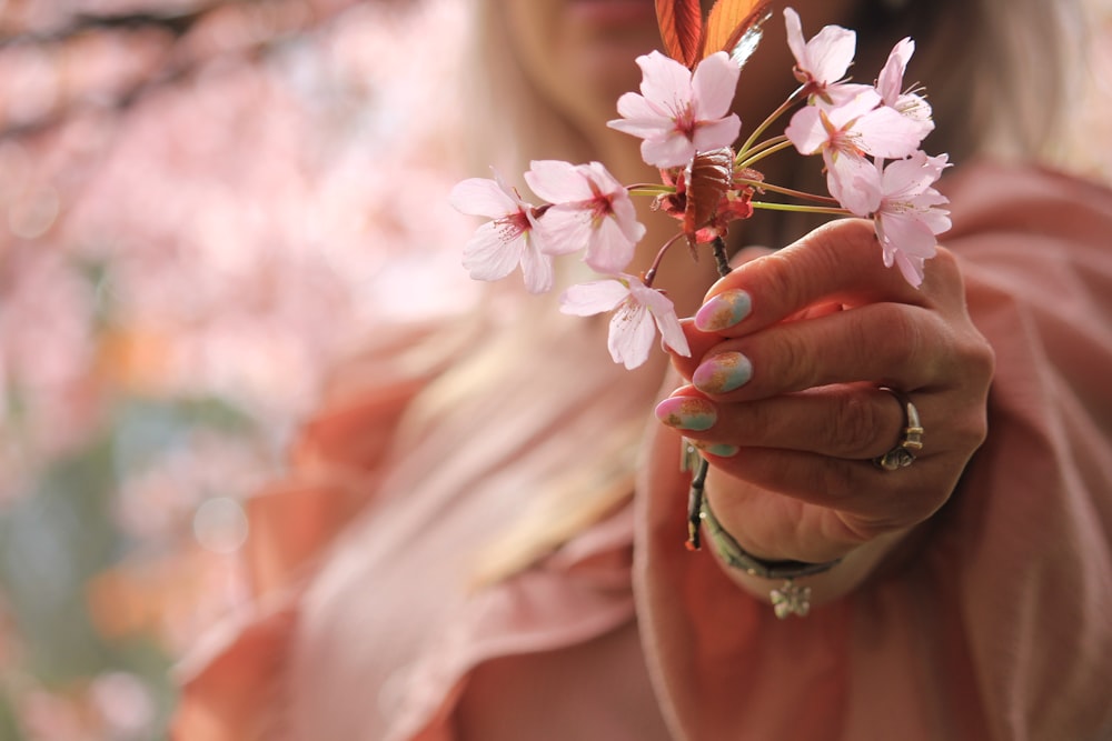 a woman holding a flower in her hand