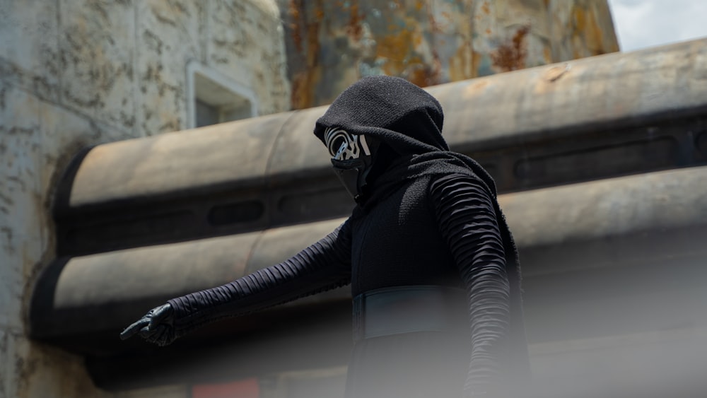 a person in a black hood and a black mask