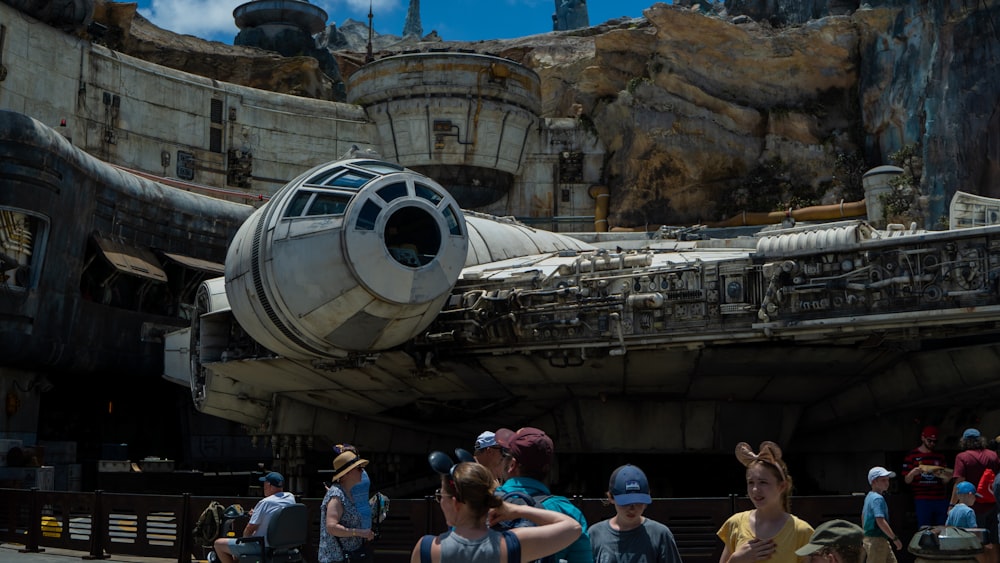 a group of people standing in front of a star wars vehicle