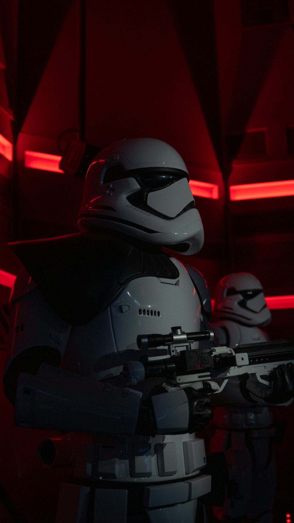 Un personaje de Star Wars sosteniendo un arma en una habitación oscura